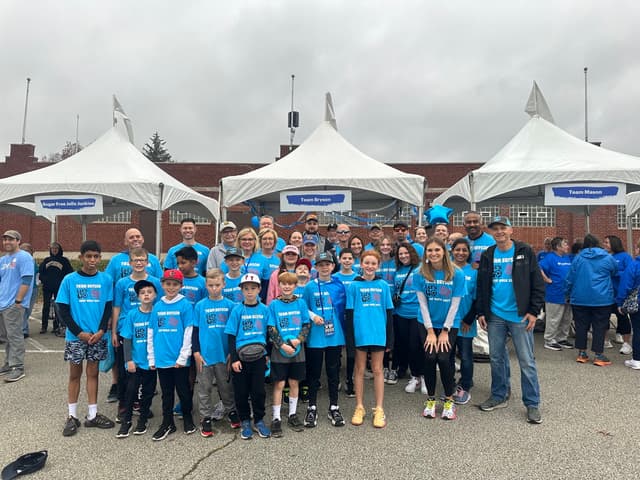 The team in bright blue Let’s Go shirts in front of the Team Bryson tent on an overcast walk day